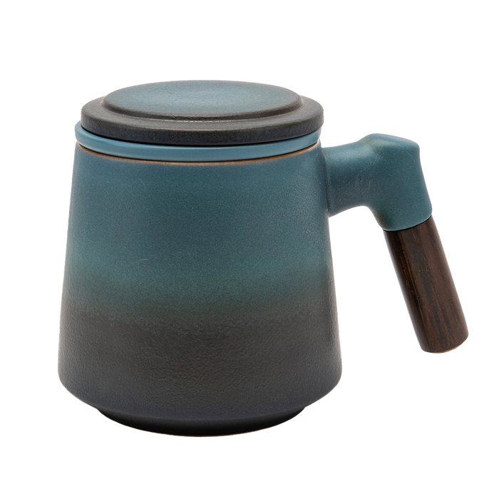 A blue ceramic tea infuser cup with a removable lid and a wooden handle.
