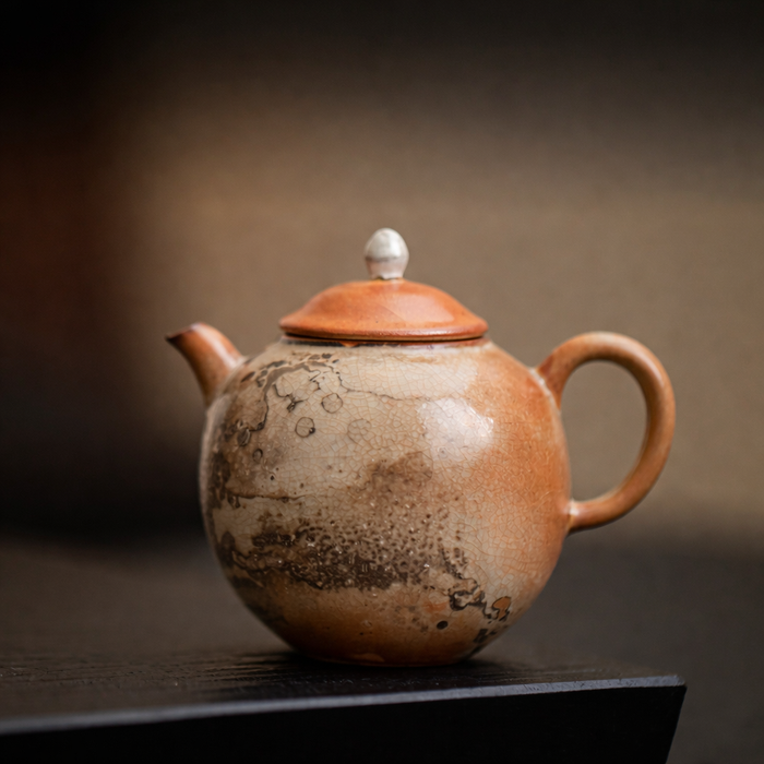 Ceramic teapot with a brown glaze on a dark surface