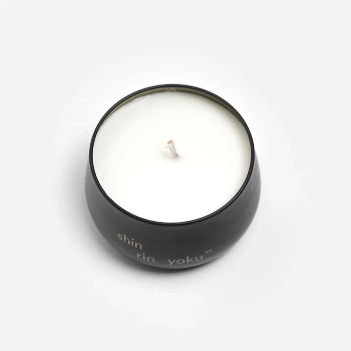 Candle in a black container with 'shin rin yoku' branding on a white background