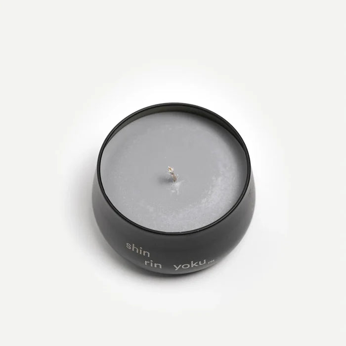 Candle in a black container with 'shin rin yoku' branding on a white background