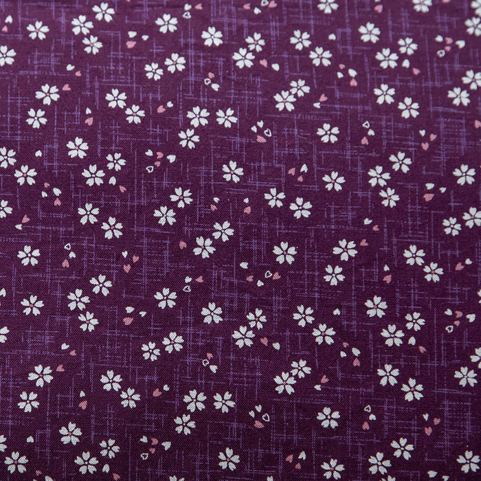 Close-up view of purple fabric with a Sakura pattern featuring white and pink flowers.