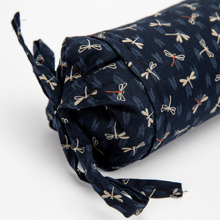 Roll of navy fabric with dragonfly pattern on a white background