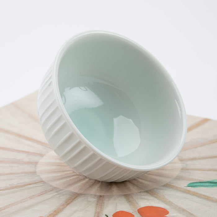 White ceramic bowl on a textured surface with a white background