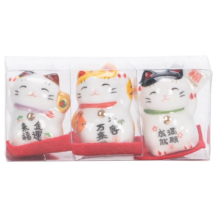 Three lucky cat figurines in packaging with red accents on a white background
