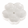 A white ceramic flower-shaped incense holder with a central hole, featuring embossed petal details and a smooth glossy finish, set against a plain white background.
