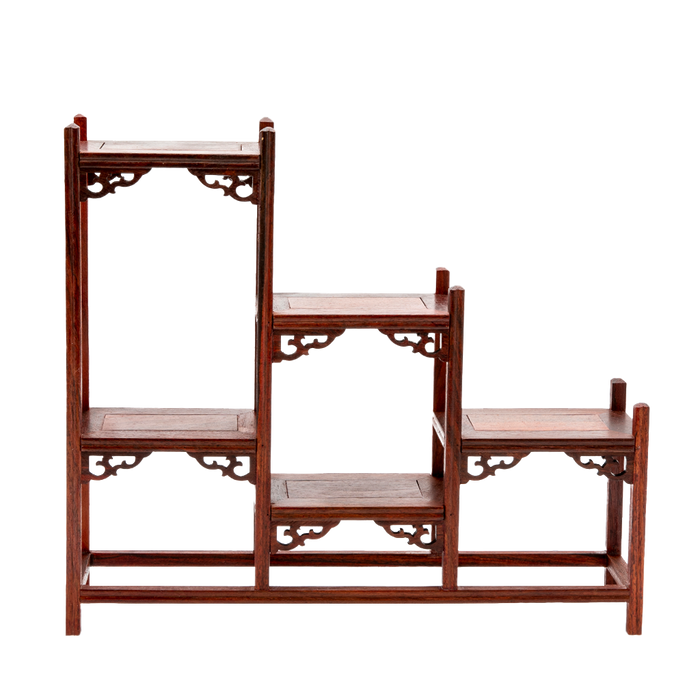 A traditional Japanese ornate rosewood shelf with scroll detailing and a stagnated 'step' design.