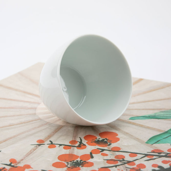 White ceramic bowl on a decorative fan with floral patterns