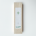 Wooden box with a small white card featuring a green design on a light gray background