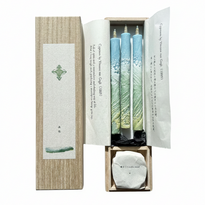 Set of three candles in a decorative box with a white background