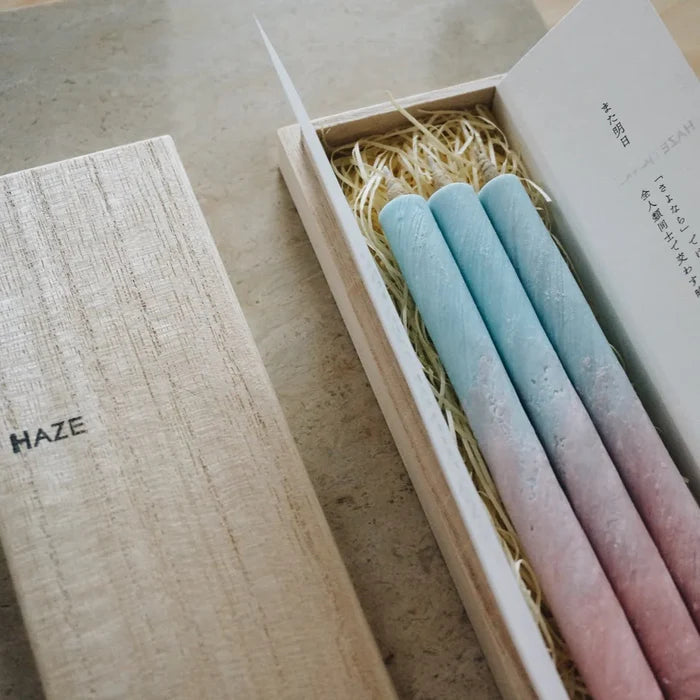 Gradient candles in a wooden box with 'HAZE' branding.