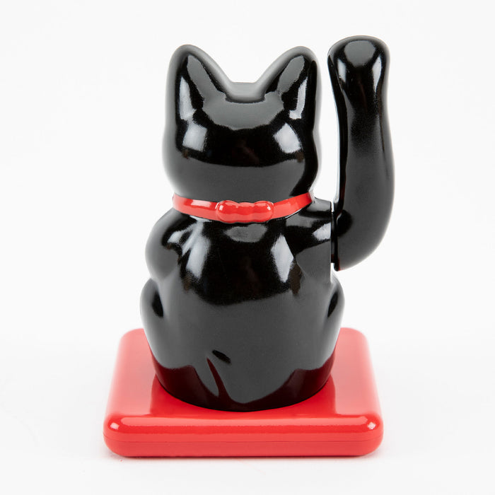 Maneki Neko in black facing backwards on a white background.