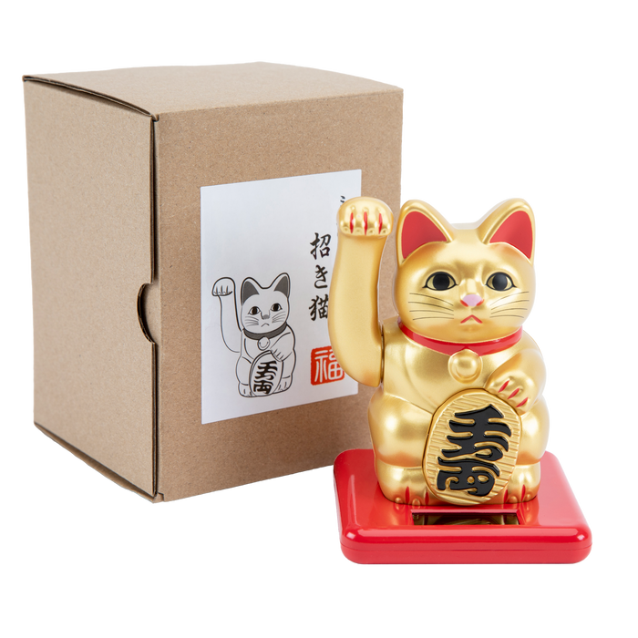 Maneki Neko in gold with a cardboard box behind it.