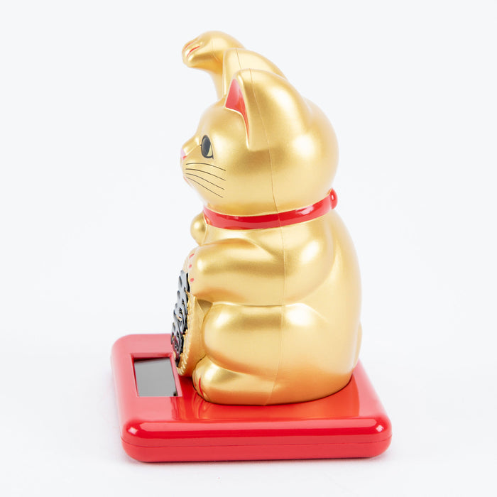 Gold maneki-neko cat on a red base with a white background